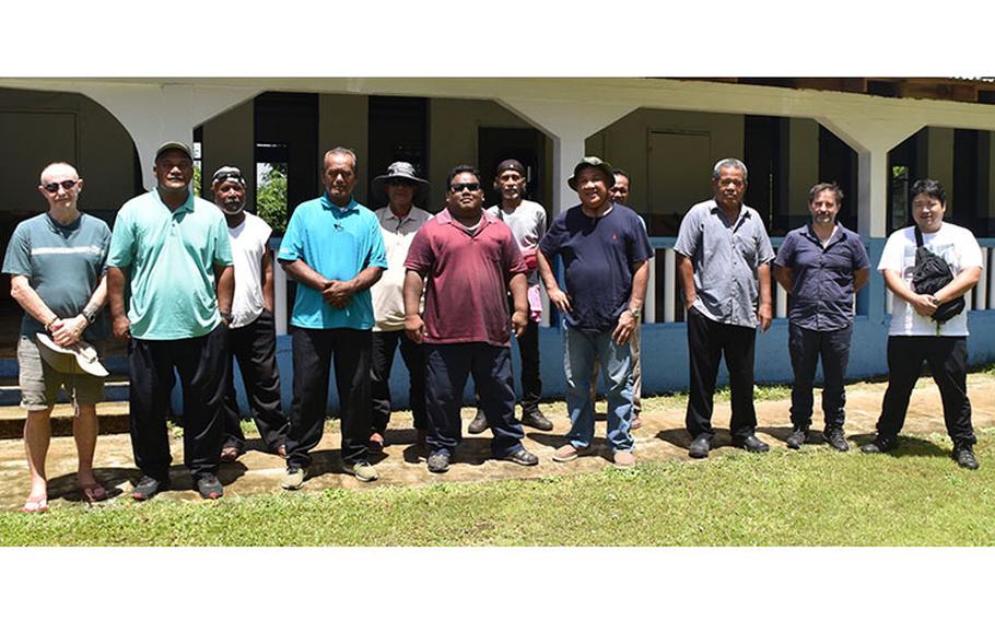 A team that visited traditional Indigenous sites on Tonoas island in Chuuk on July 4, 2023, is joined by traditional chiefs of Tonoas; Mayor Gradvin Aisek, right of center, wearing a hat; and some of the Chuuk Lagoon Battlefield Project survey team members from the University of Guam. They are seen in front of the Tonoas Municipal Office, formerly a school built for Chuukese students before World War II.