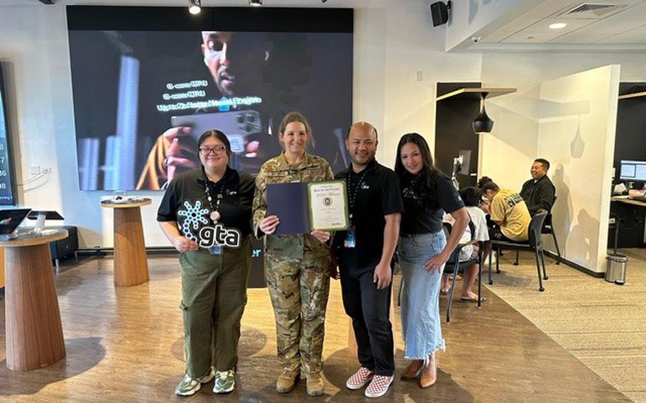 GTA group photo as Stars and Stripes Pacific Commander Lt. Col. Marci Hoffman presents Best cellphone provider award to GTA staff.