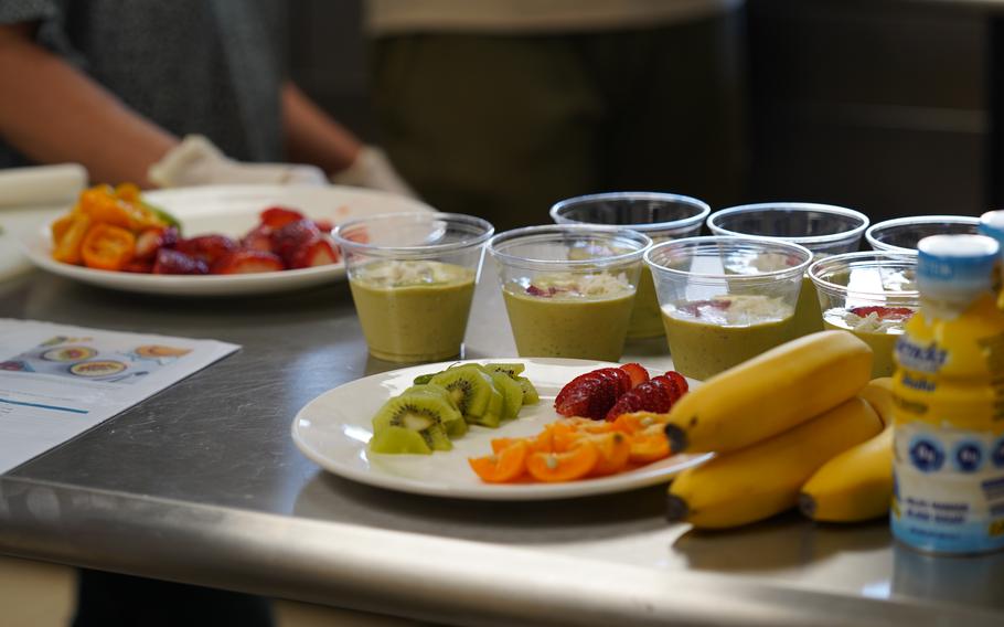 Fruits such as kiwi fruits and oranges are on the table.