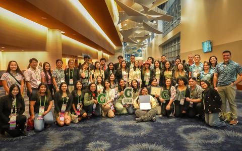 Photo Of The students pose on the floor of the coference site.