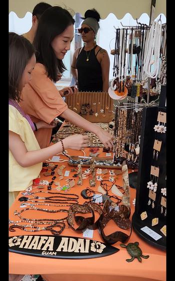 Visitors shop for locally made jewelry and crafts at the Tumon Night Market’s pop-up shops.
