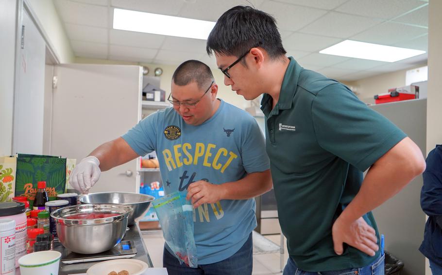 University of Guam extension animal and meat scientist Jeng-Hung “Leo” Liu looks on as a workshop participant seasons ground pork during a UOG meat processing workshop in August 2023. 