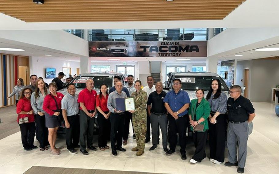 Atkins Kroll group photo as Stars and Stripes Pacific Commander Lt. Col. Marci Hoffman presents Best place to buy a car award to Atkins Kroll staff.