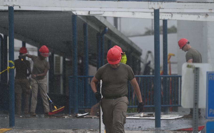 U.S. Air Force Airmen from the 554th Rapid Engineering Deployable Heavy Operational Repair Squadron Engineers, remove debris from the walkway at J.Q. San Miguel Elementary School, Mong Mong Toto, Guam, Sep. 16, 2024. The 554th REDHORSE provided aid to reenforce the stable structure of the elementary school to pass their health inspection.