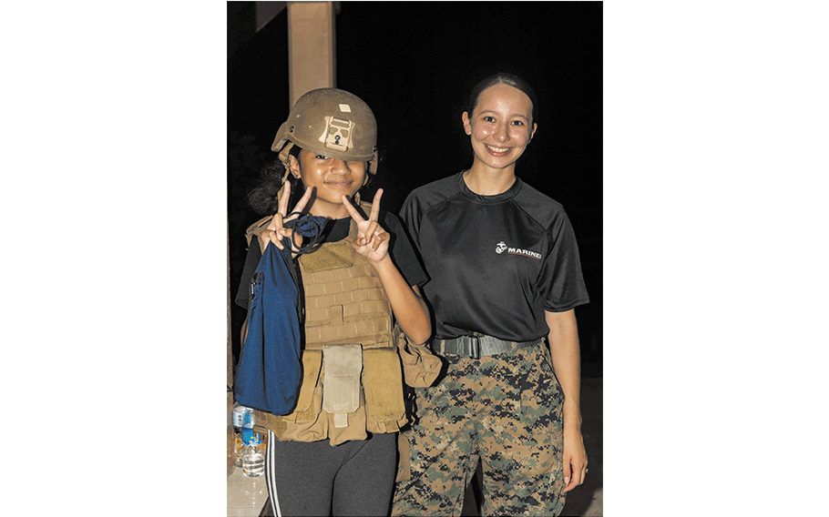 U.S. Marine Corps Lance Cpl. Victoria Luna, an administrative specialist with Combat Logistics Battalion 13, Combat Logistics Regiment 17, 1st Marine Logistics Group, poses with the local community for a photo during a local night market as part of exercise Koa Moana 24, at Koror, Palau, Aug. 24, 2024. Marines from Koa Moana 24 assisted recruiters from Recruiting Station San Diego, 12th Marine Corps District Headquarters, in expanding their presence in Palau During Koa Moana’s deployment throughout the Indo-Pacific region, U.S. Marines and Sailors from I Marine Expeditionary Force work to strengthen alliances and partnerships with development of interoperable capabilities, combined operations, theater security cooperation, and capacity-building efforts. 