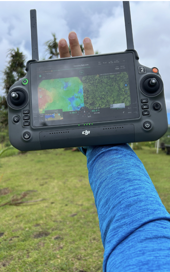 A DJI drone remote controller displaying a side-by-side comparison of the LiDAR data and the RGB imagery of a terrace in Ameliik, Palau.