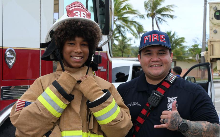 Andersen Middle School student and Andersen Fire Captain J. Cruz pose for a picture during Andersen Middle School Career Day at Andersen Air Force Base, Guam, June 4, 2025. Multiple military members volunteered to showcase equipment and skills they use in everyday life in their respective jobs. 