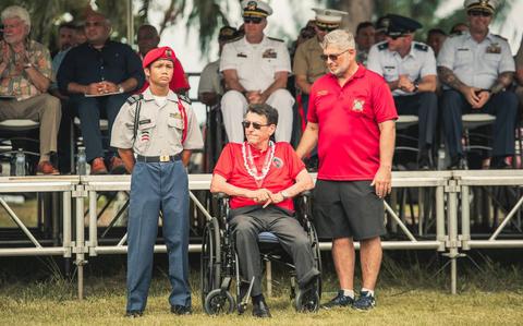 Photo Of U.S. Navy veteran Brian J. Miranda in a wheelchair. two people are standing beside him.