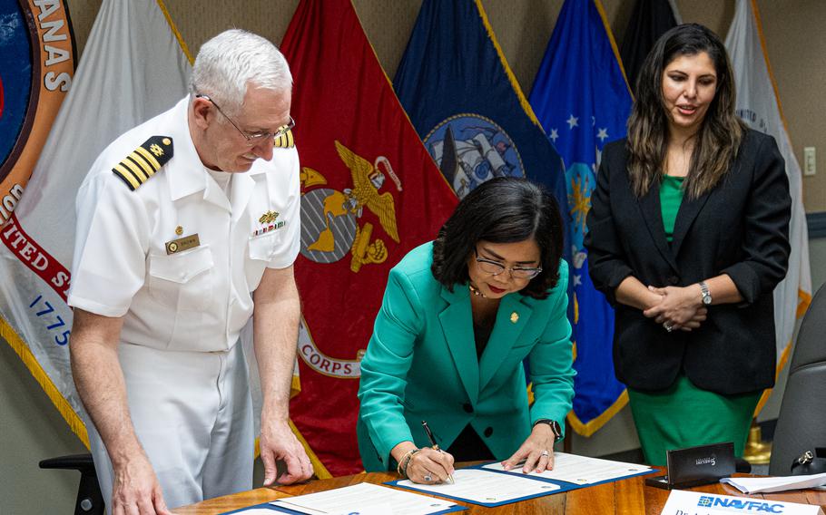 University of Guam President Anita Borja Enriquez, center, signs the Memorandum of Understanding to formalize an internship pathway for UOG’s engineering students on Nov. 1, 2023. Capt. Troy Brown, Commanding Officer of Naval Facilities Engineering Systems Command Marianas, left, signs for NAVFAC as Bharti Hemlani, Lead Human Resources Specialist and acting HR Director at NAVFAC Marianas, facilitates.