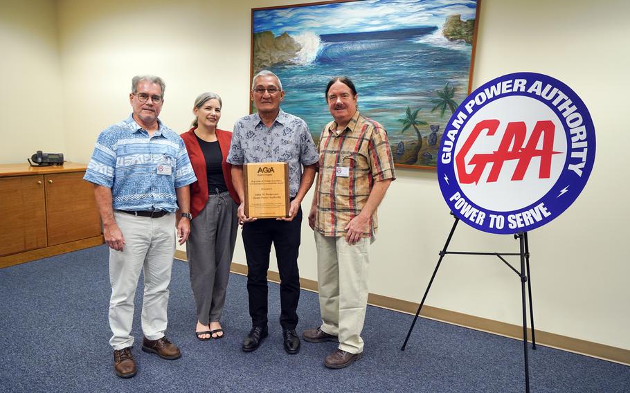 GPA GM John M. Benavente holds the award. three people are beside him.