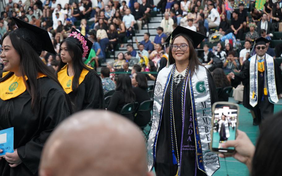 Accounting major Camille Joyce Mendoza Ricafort walks into the Calvo Field House arena at the start of the UOG Fanuchånan 2024 Commencement Ceremony on Dec. 15.  