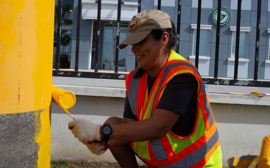 Melissa Swenson, 36th Operational Medical Readiness Squadron family member, paints a power pole in Mongmong-Toto-Maite, Guam, Feb. 27, 2021. The yellow paint is an effort to increase nighttime visiability on the busy road. (U.S. Air Force photo by SSgt Nicholas Crisp)