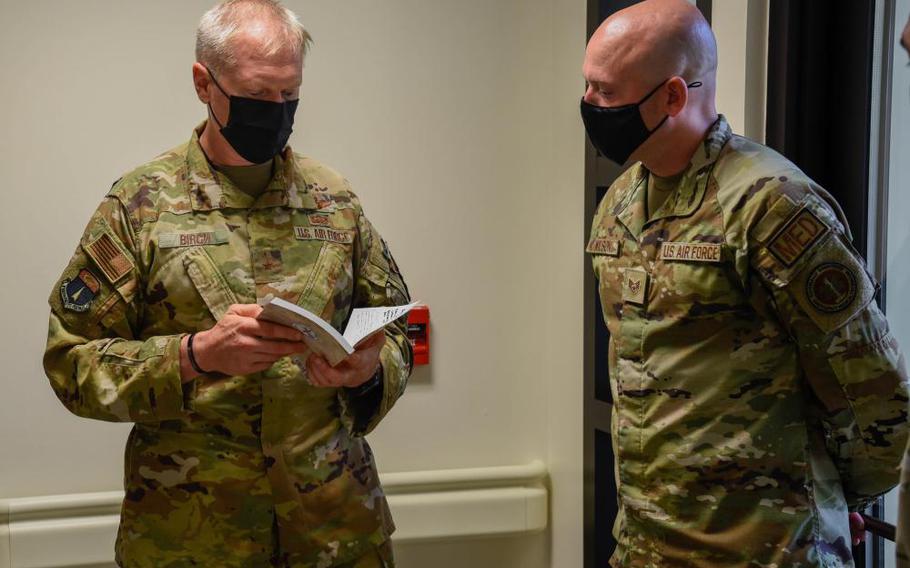 U.S. Air Force Staff Sgt. Zachary Wilson, non-commissioned officer in charge, education and training with the 36th Wing Medical Group, receives a book from U.S. Air Force Brig. Gen. Paul R. Birch, 36th Wing commander, and U.S. Air Force Chief Master Sgt. John E. Payne, 36th Wing command chief, at Andersen Air Force Base, Guam, July 6, 2022. The Linebacker 2: A View from the Rock written by James R. McCarthy is a story about the Air Force’s history and participation in Operation Linebacker 2. (U.S. Air Force