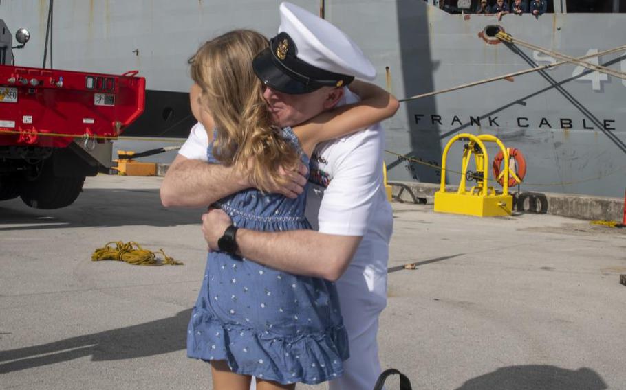 Senior Chief Master-at-Arms Shawn Stewart, assigned to the Emory S. Land-class submarine tender USS Frank Cable (AS 40), hugs his daughter after returning from patrol, May 16, 2022. Frank Cable has returned from conducting expeditionary maintenance and logistics in support of national security in the U.S. 7th Fleet area of operations. (U.S. Navy photo by Mass Communication Specialist 1st Class Charlotte C. Oliver/released)