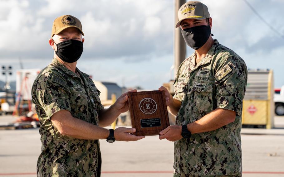 SANTA RITA, Guam (Feb. 26, 2021) Capt. Bret Grabbe, commodore of Commander, Submarine Squadron 15, presents the Battle “E” award to Cmdr. Michael McGuire, captain of the Los Angeles-class fast-attack submarine USS Key West (SSN 722). Key West is one of multiple submarine commands assigned to CSS-15 out of Polaris Point, Naval Base Guam. (U.S. Navy photo by Mass Communication Specialist 2nd Class Kelsey J. Hockenberger)