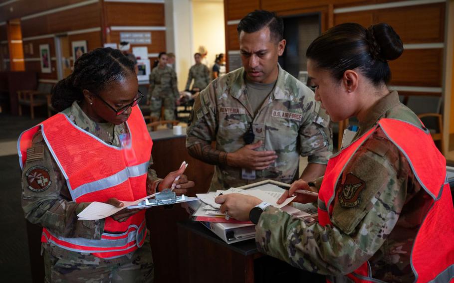 Major Winnebelle Smith, Tech. Sgt Andy Renteria, and Capt. Anne Gielyn Auer, in-processing team, review patient information during a Mass Casualty Exercise at Andersen Air Force Base.