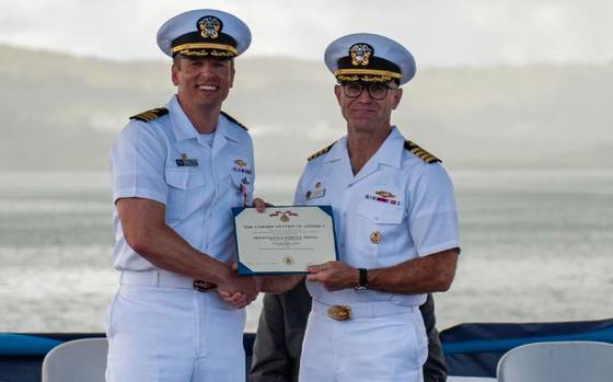 Photo Of Cmdr. Andrew Domina, commanding officer of the Los Angeles-class fast-attack submarine USS Springfield (SSN 761), left, receives an award from Capt. Neil Steinhagen, commander, Submarine Squadron 15, during a change of command ceremony, July 30.