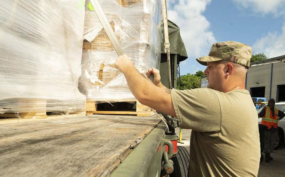 U.S. Air Force Tech. Sgt. Gregory Allen, 36th Logistics Readiness Squadron ground transportation noncommissioned officer, tightens a strap to hold down pallets of ready-to-eat meals in Dededo, Guam, Nov. 30, 2022. Members of the ground transportation team moved about 50,000 pounds of cargo in support of the 71st Operation Christmas Drop. (U.S. Air Force photo by Airman Spencer Perkins)