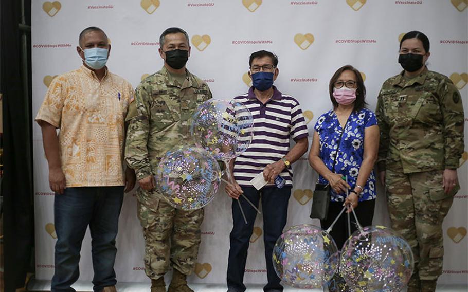 From left, Carlos Taitano, director, Global Learning & Engagement, UOG; Maj. Luis Cruz, incident commander for Operation Liberate Guam, Uldarico Bernaldez (husband), Evelyn Bernaldez, and Capt. Denise Chargualaf, commander, Task Force Medical and Force Health Protection, pose for a group picture at the University of Guam Calvo Fieldhouse Clinic in Mangilao on June 11, in celebration of Mrs. Bernaldez for receiving the 100,000th COVID-19 vaccine.