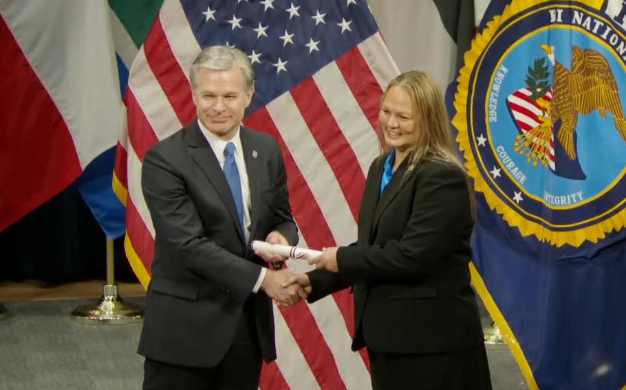 Capt. Barbara Tayama receives her certificate of completion of the Federal Bureau of Investigation (FBI) National Academy Session 292 from FBI Director Christopher Wray.