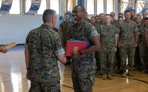 Photo Of U.S. Marine Corps Staff Sgt. Marcellous Dixon, training chief, Marine Corps Base Camp Blaz, shakes hands with Col. Ernest Govea, commanding officer, MCB Camp Blaz, during an award ceremony.