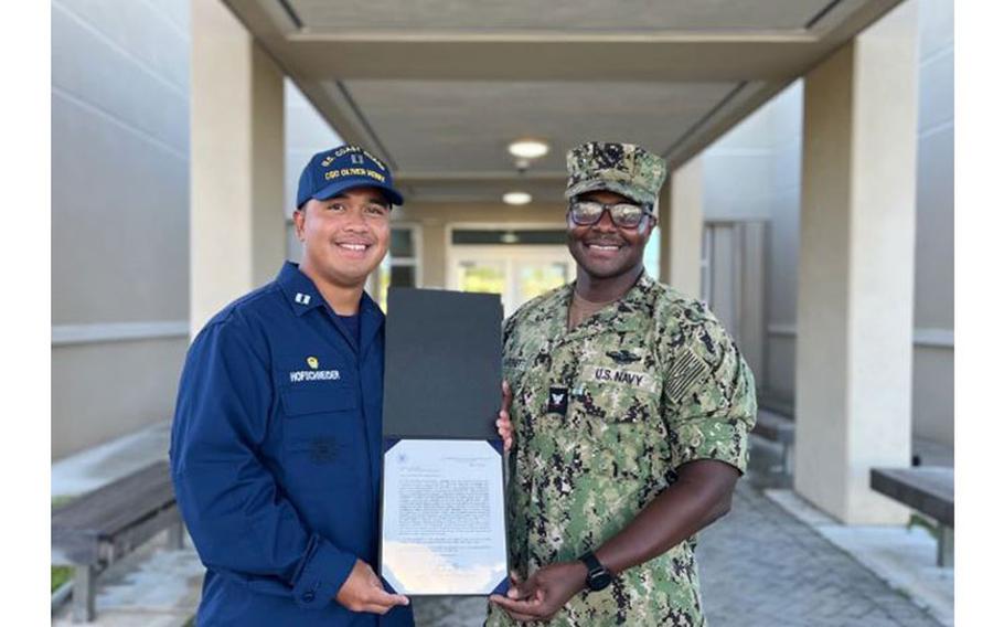 Lt. Freddy Hofschneider, commanding officer of USCGC Oliver Henry (WPC 1140), presents a U.S. Coast Guard Letter of Commendation to Petty Officer 3rd Class Christopher Hardnett on behalf of Capt. Nick Simmons, commander of U.S. Coast Guard Forces Micronesia/Sector Guam, at an all-hands ceremony on Navy Base Guam at the new Branch Medical Clinic on April 27, 2023. Hardnett provided medical support for the Oliver Henry's 43-day expeditionary patrol in 2022. (U.S. Coast Guard photo by Lt. j.g. Marissa Marsh)