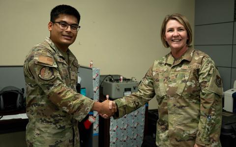 Photo Of U.S. Air Force Senior Airman Peter Nguyen, Aircrew Flight Equipment Journeyman, left, shakes hands with Chief Master Sgt. Katie McCool, Pacific Air Forces command chief, after being coined for excellent performance during Operation Christmas Drop 2024.