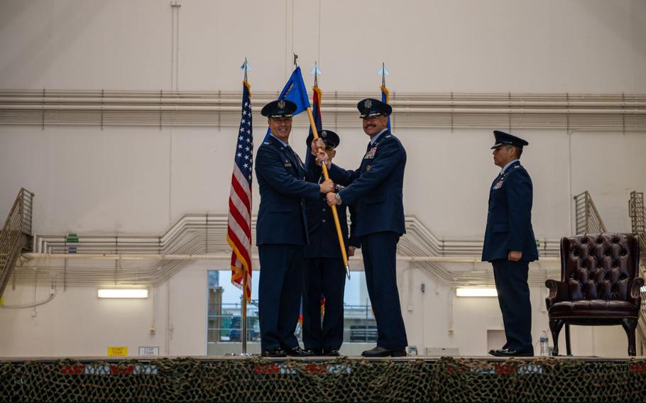 U.S. Air Force Col. Dan Cooley, commander of the 36th Wing, hands the guidon to Col. Andrew Miller, incoming commander of the 36th Contingency Response Group, during a change of command ceremony.