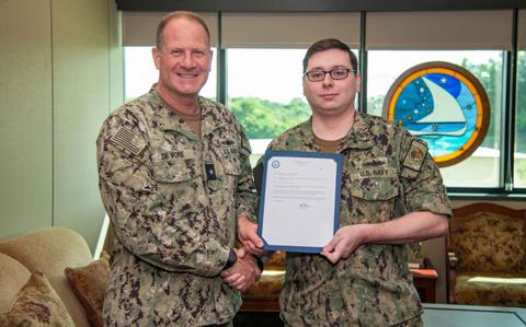 Photo Of Operations Specialist 1st Class Wilbur Theis receives his certificate of appointment to first class petty officer by Rear Adm. Brent DeVore, commander, Joint Region Marianas, during a frocking ceremony at JRM headquarters, Dec. 12. 