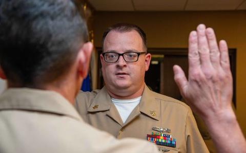 Photo Of U.S. Navy Chief Cryptologic Technician (Technical) Michael Gaffney recites the oath of reenlistment to Rear Adm. Greg Huffman, commander, Joint Region Marianas, during a reenlistment ceremony at JRM headquarters, Apr. 1.