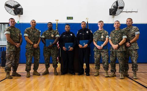 Photo Of U.S. Marine Corps senior leaders pose for a group photo with the new graduates of the Naval Security Guard Training course after a graduation ceremony on Marine Corps Base Camp Blaz, Guam.