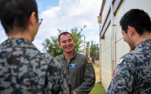 Photo Of U.S. Air Force Capt. Brian Reed, 374th Operations Group deputy chief of group standardization and evaluation, speaks with Japan Air Self-Defense Force members in Japanese during exercise Cope North 25 on Andersen Air Force Base, Guam.