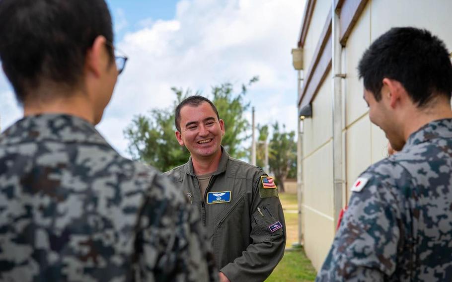 U.S. Air Force Capt. Brian Reed, 374th Operations Group deputy chief of group standardization and evaluation, speaks with Japan Air Self-Defense Force members in Japanese during exercise Cope North 25 on Andersen Air Force Base, Guam.