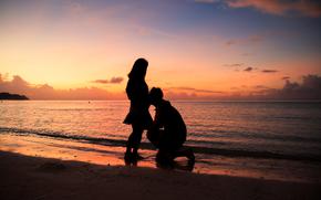 silhouette of couple on the beach with a beautiful sunset in background