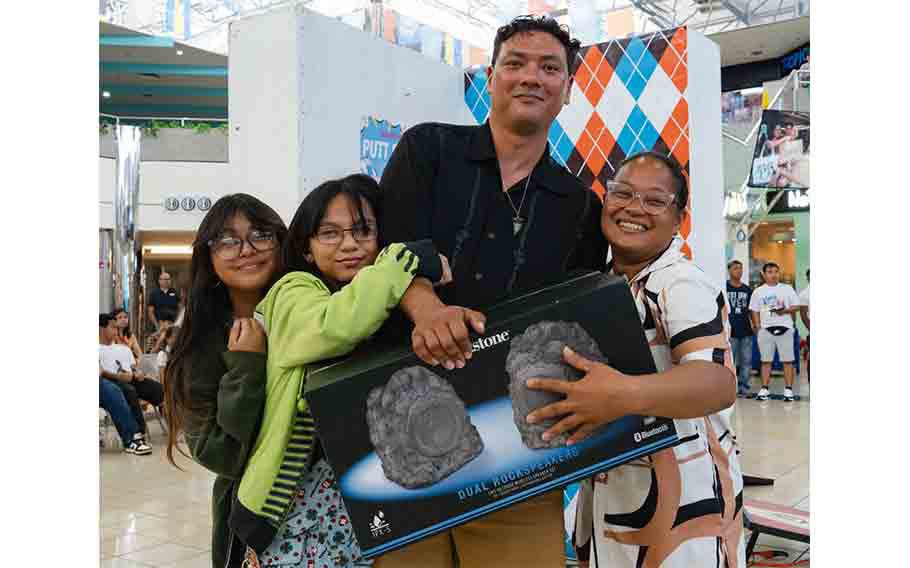 A dad enjoys his raffle prizes at the Micronesia Mall Father’s Day event in 2024.